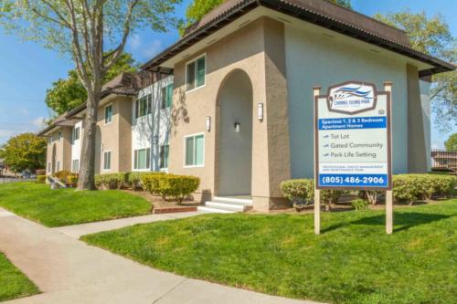 Apartment exterior with sign Channel Island Park Apartment Sign. Spacious 1, 2, & 3 Bedroom Apartment Homes. *Tot Lot *Gated Community *Park Life Setting, 805-486-2906, Professional Onsite Management and Maintenance Team 